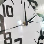 Elegant wall clock featuring a minimalist black and white face with bold numerals and sleek hands, perfect for contemporary interior decor.