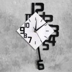 Contemporary wall clock featuring a white square face with black numerals and a black pendulum, mounted on a textured gray wall.