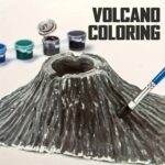 A realistic volcano model with a hollow crater, accompanied by small paint pots and a brush, designed for educational and creative science projects.