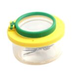 Magnifying glass with a yellow lid and green handle for educational exploration.