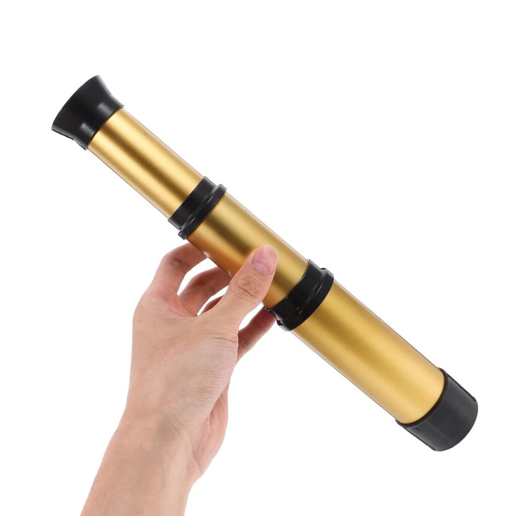 Hand holding a gold-colored telescope for science exploration and educational activities. Perfect for science enthusiasts and students interested in astronomy and outdoor observation.