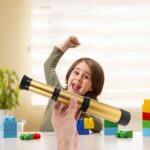 Child excitedly looking through a toy telescope with colorful building blocks on the table, promoting science exploration and educational fun.