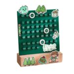 A wooden calendar with a green background featuring days, dates, and illustrations of a coffee cup, trees, a gift, and a girl reading a book, designed for educational and decorative purposes.