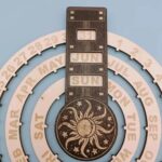 A detailed image of a sun and moon themed calendar puzzle with rotating rings displaying months, days, and dates, designed as an educational science toy and decorative piece.