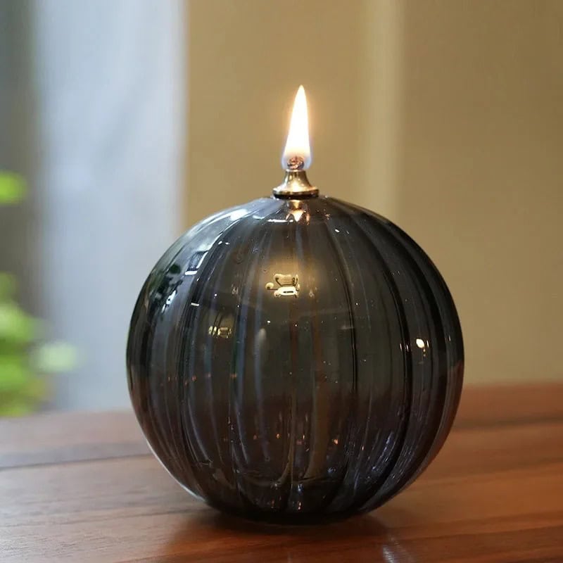 Aromatic Black Glass Candle with Flame Elegant black glass candle with a lit flame, showcasing a sleek spherical design perfect for home decor and educational science displays.