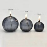 LED pumpkin candles with flickering flames in three sizes: 10cm, 8cm, and 6cm, featuring a dark, glossy finish with subtle vertical stripes.