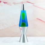 Modern lava lamp with green and blue wax inside a clear glass tube, set on a silver base, creating a calming and decorative lighting effect.