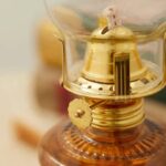 Antique-style oil lantern featuring a glass chimney, brass accents, and a wick for traditional lighting demonstrations.