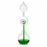 Glass distillation apparatus with green liquid for science experiments.