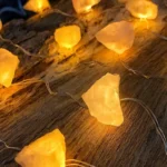 Warm yellow glow rock string lights on wooden surface, decorative lighting for home or events.