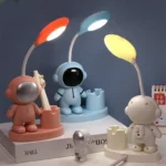 Cute astronaut and alien desk lamps with colorful lights for kids' rooms and science-themed decor.