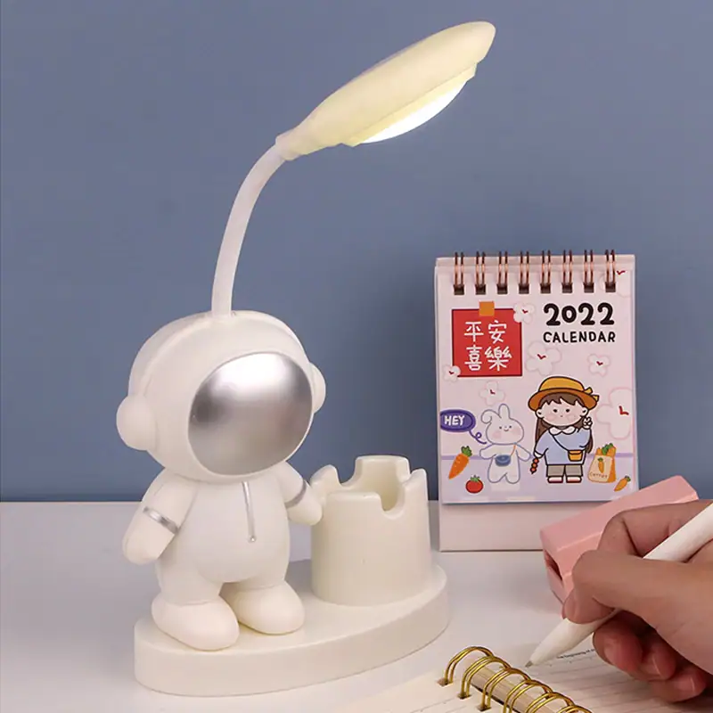 Cute Astronaut Desk Lamp with Calendar and Pen Holder Astronaut-themed LED desk lamp with flexible neck, integrated calendar, and pen holder, perfect for a space-inspired workspace or educational setting.