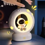 Moon-shaped night light featuring a cute astronaut holding a yellow duck, ideal for children's rooms and space-themed decor.