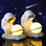 Astronaut-themed night lights featuring two astronauts holding glowing planets, perfect for children's rooms and educational decor.