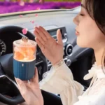 Portable car air purifier emitting pink flower-like particles, enhancing air quality and creating a calming atmosphere inside the vehicle.