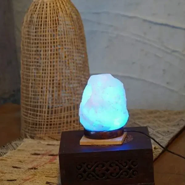 Illuminated salt lamp with a wooden base, placed on a decorative surface with rattan decor in the background, creating a cozy and natural ambiance.