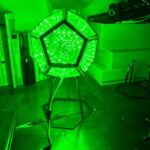 Green LED geodesic dome light on stand, ideal for science decor and educational displays, creating a vibrant, futuristic atmosphere in science labs or classrooms.