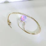 Elegant necklace featuring a glowing, iridescent orb pendant on a delicate chain, perfect for science-inspired jewelry enthusiasts.