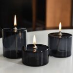 Set of three black flameless LED tea lights with flickering flames, ideal for safe, decorative lighting in home decor or educational displays.