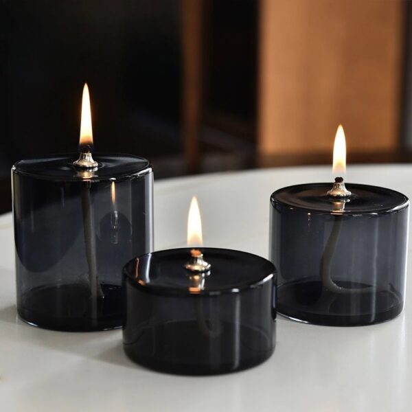 Set of three black flameless LED tea lights with flickering flames, ideal for safe, decorative lighting in home decor or educational displays.