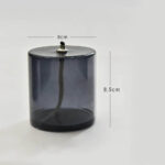 Modern water dispenser with a transparent cylindrical container measuring 8.5cm in height and 8cm in diameter, featuring a sleek black lid and a flexible tube for dispensing water.