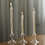 Glass candle holders with lit candles, perfect for home decor and creating a cozy ambiance. Transparent design adds a touch of sophistication to any setting.