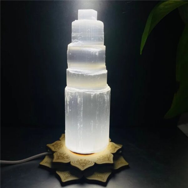 Salt lamp tower with a wooden base, illuminated to showcase its natural crystalline structure. Perfect for science decor and educational settings.