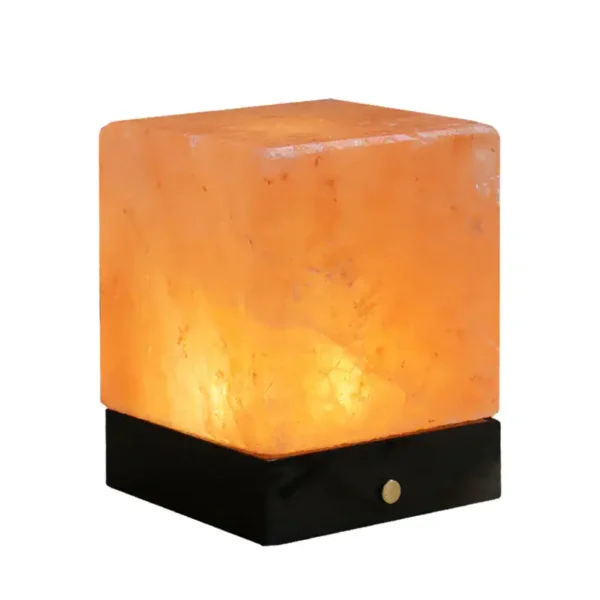 Himalayan salt lamp emitting warm glow on black wooden base, ideal for home decor and relaxation.