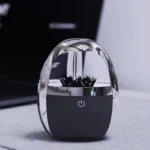 Modern crystal ball-shaped desk organizer with a black base and decorative black accents, perfect for storing office supplies in a stylish way.
