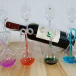 Colorful test tubes with liquid chemicals and a wine bottle in the background, demonstrating a science experiment on color mixing and chemical reactions.
