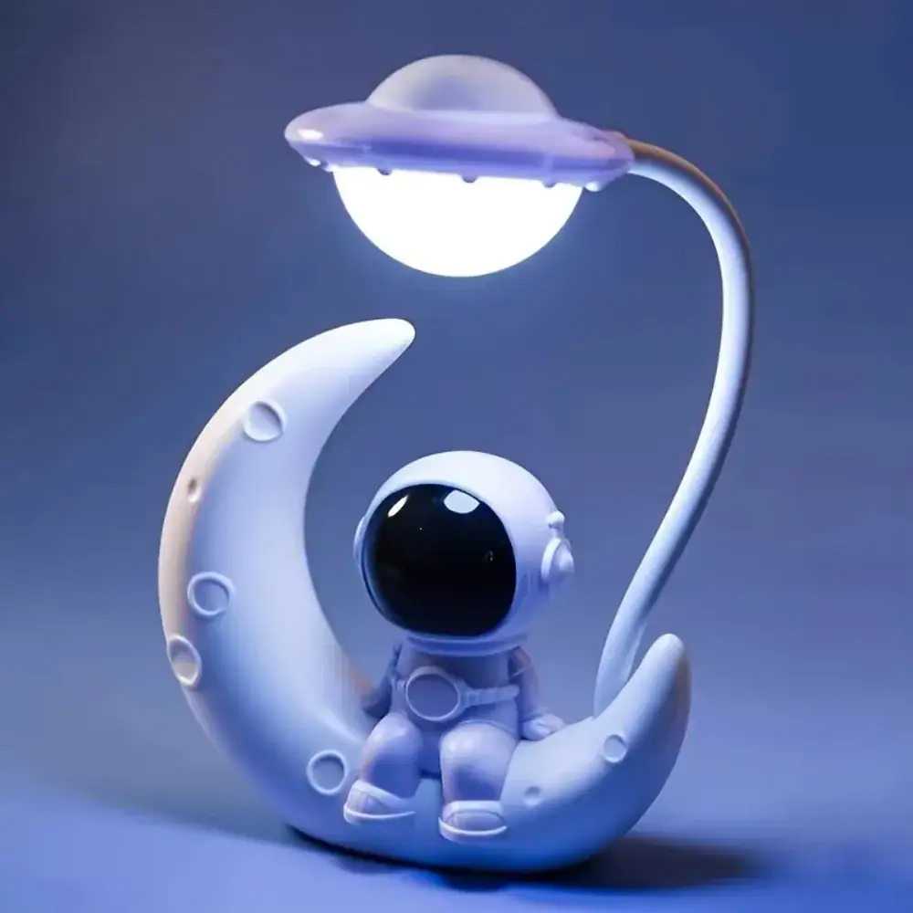 Adorable astronaut toy resting on a moon-shaped stand illuminated by a planet-shaped lamp, perfect for space-themed decor or educational purposes.