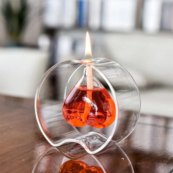 Glass oil lamp with a flame and orange liquid inside, decorative science-inspired piece.