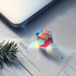 A colorful glass prism casting a rainbow spectrum of light onto a white surface, demonstrating light refraction and dispersion for educational science experiments.