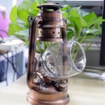 Vintage oil lantern with glass chimney and metal frame, ideal for decorative or educational purposes.