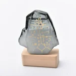 Decorative crystal sculpture with gold-etched symbols on a wooden base, ideal for science-themed decor and educational displays.