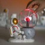 Astronaut and plasma ball science toy for educational and decorative purposes.
