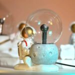 A plasma ball with an astronaut figurine, creating a captivating science decor piece. Perfect for educational spaces or science enthusiasts, combining fun and learning.