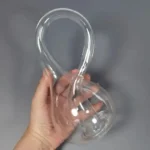 Glass hourglass-shaped science apparatus for educational experiments and decor.