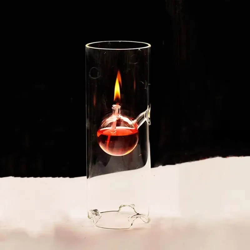 Science Gadgets | Science Decor & Educational Toys Shop A glass test tube with a small round-bottom flask inside, containing a red liquid and a visible flame, demonstrating a science experiment.