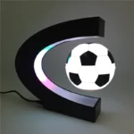 Modern football-shaped LED night light featuring a black and white soccer ball design, mounted on a crescent moon-shaped black frame, ideal for sports-themed decor.