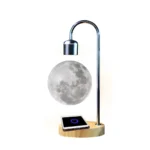 Moon-shaped desk lamp with adjustable metal arm, wireless charging pad, and wooden base, ideal for science-themed decor and educational purposes.