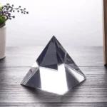 A sleek, transparent acrylic pyramid with sharp edges, perfect for science displays or educational purposes.