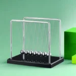 Classic Newton's Cradle with metal balls on a black base, demonstrating physics principles of momentum and energy transfer.