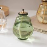 A glass diffuser bottle filled with lavender-colored liquid, featuring a metal cap and a wick for aromatic diffusion. Perfect for home decor and creating a calming atmosphere.