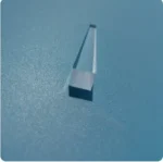 Precision microbalance calibration weight on a smooth blue surface, used for accurate measurement in scientific experiments and laboratory settings.