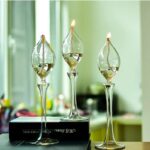 Glass science experiment lamps with flames on a black base, decorative and educational.