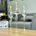 Elegant glass candle holders with floating candles on a wooden table.