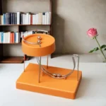 Orange magnetic ball and metal track science toy on a white table.
