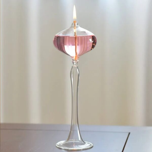 Elegant glass candle holder with pink liquid wax and a lit flame, creating a warm and inviting ambiance.