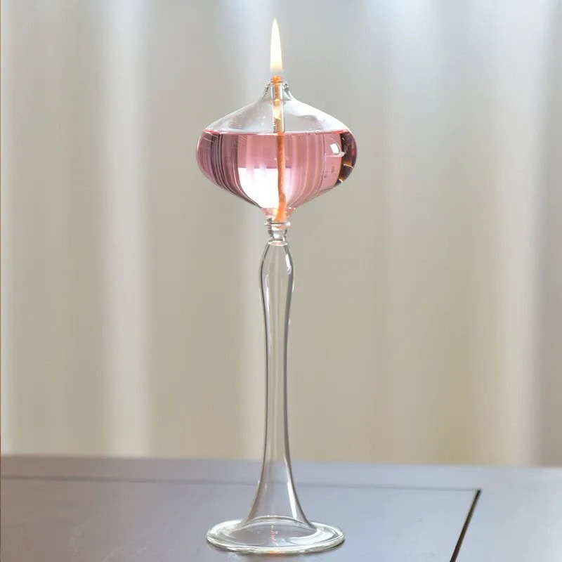 Pink Liquid Candle in Glass Holder Elegant glass candle holder with pink liquid wax and a lit flame, creating a warm and inviting ambiance.